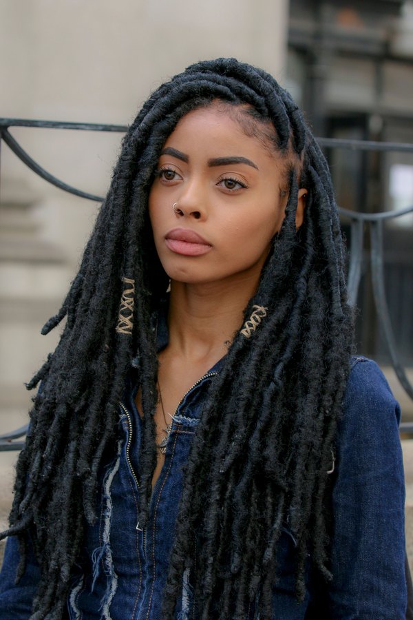 Woman with long mature locs in a denim jacket